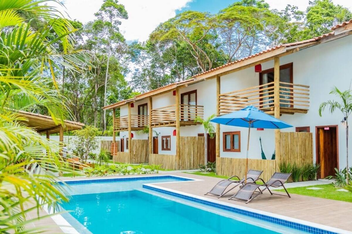 A poolside area with a clear blue pool, wooden deck, and lounge chairs.