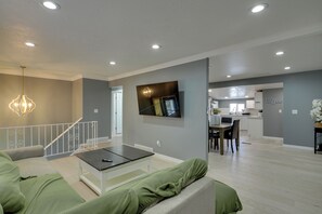 Un salon moderne avec un canapé, une table basse et un téléviseur fixé au mur.