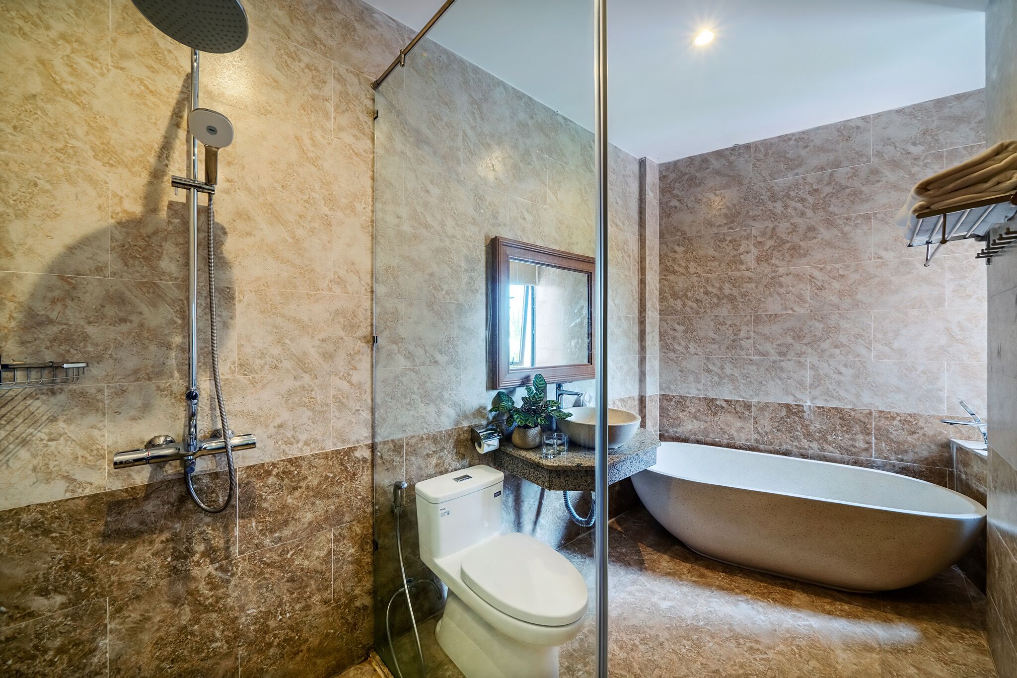 A modern bathroom with a freestanding bathtub, a showerhead, and a toilet.