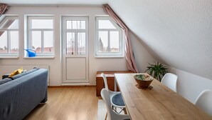 Una habitación con una mesa de comedor, sillas, un sofá y ventanas.