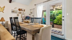 Un comedor con una mesa de madera, sillas negras y un tapete azul.