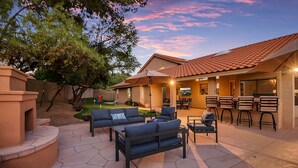 A patio with outdoor furniture, a barbecue area, and a landscaped yard.