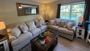 Een woonkamer met een bank, salontafel en een plafondventilator.