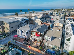 Un quartier résidentiel situé sur la côte, avec des maisons, une plage et une vue dégagée sur l’océan.