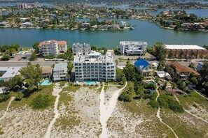 An aerial view of a coastal hotel with multiple buildings, a swimming pool, and a beach area.