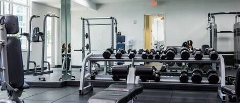 A gym with various exercise equipment, including dumbbells and weight machines.