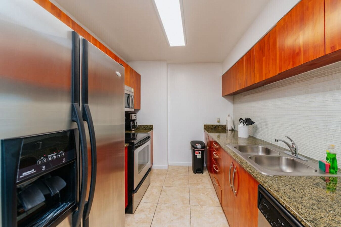 Una cocina funcional equipada con refrigerador, horno, microondas y lavaplatos.