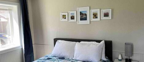 A bedroom with a bed, a nightstand, a lamp, and a ceiling fan.