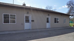 A single-story building with a flat roof, two doors, and two windows.