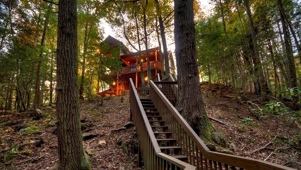 A wooden staircase leading to a cabin in a forest. - Nearby creek, cozy hot tub, pool table, and more! - Castle Creek (Cherry Log)
