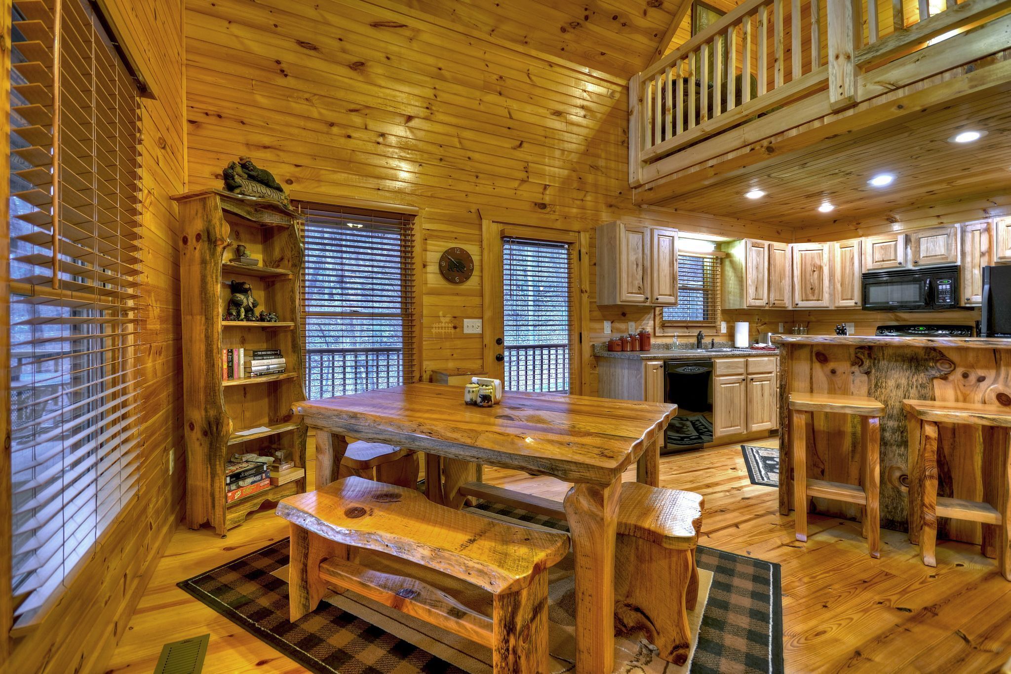L’intérieur d’une cabane en bois comprend un coin repas, une cuisine et une chambre à coucher située en mezzanine.