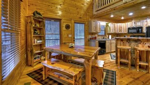 A wooden cabin interior with a dining area, kitchen, and a loft bedroom. - Scenic Views, Hot Tub Soaks, Firepit Roasts, Cookouts & Nearby Adventures - Cardinal's Crossing (Morganton)