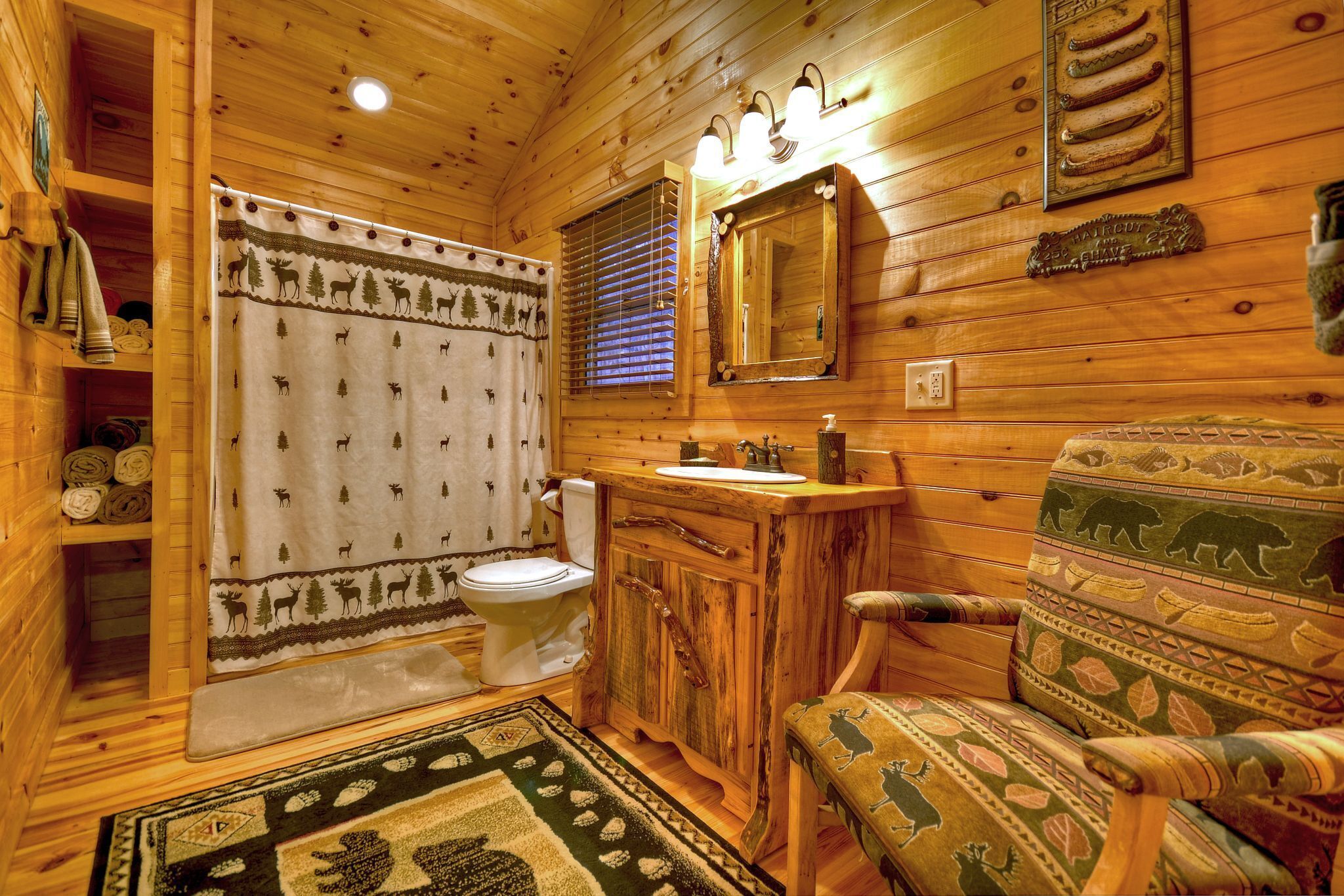 A wooden cabin bathroom with a toilet, sink, and mirror.