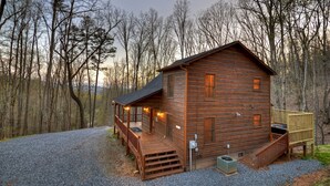 A wooden cabin with a porch, a small deck, and a gravel driveway. - Scenic Views, Hot Tub Soaks, Firepit Roasts, Cookouts & Nearby Adventures - Cardinal's Crossing (Morganton)