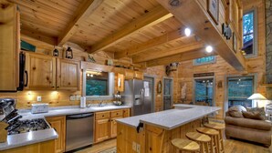 Een houten chalet van binnen met een keuken, een bar en zitplaatsen.