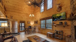 L’intérieur d’une cabane en rondins comprend un coin repas, une cuisine et un salon.