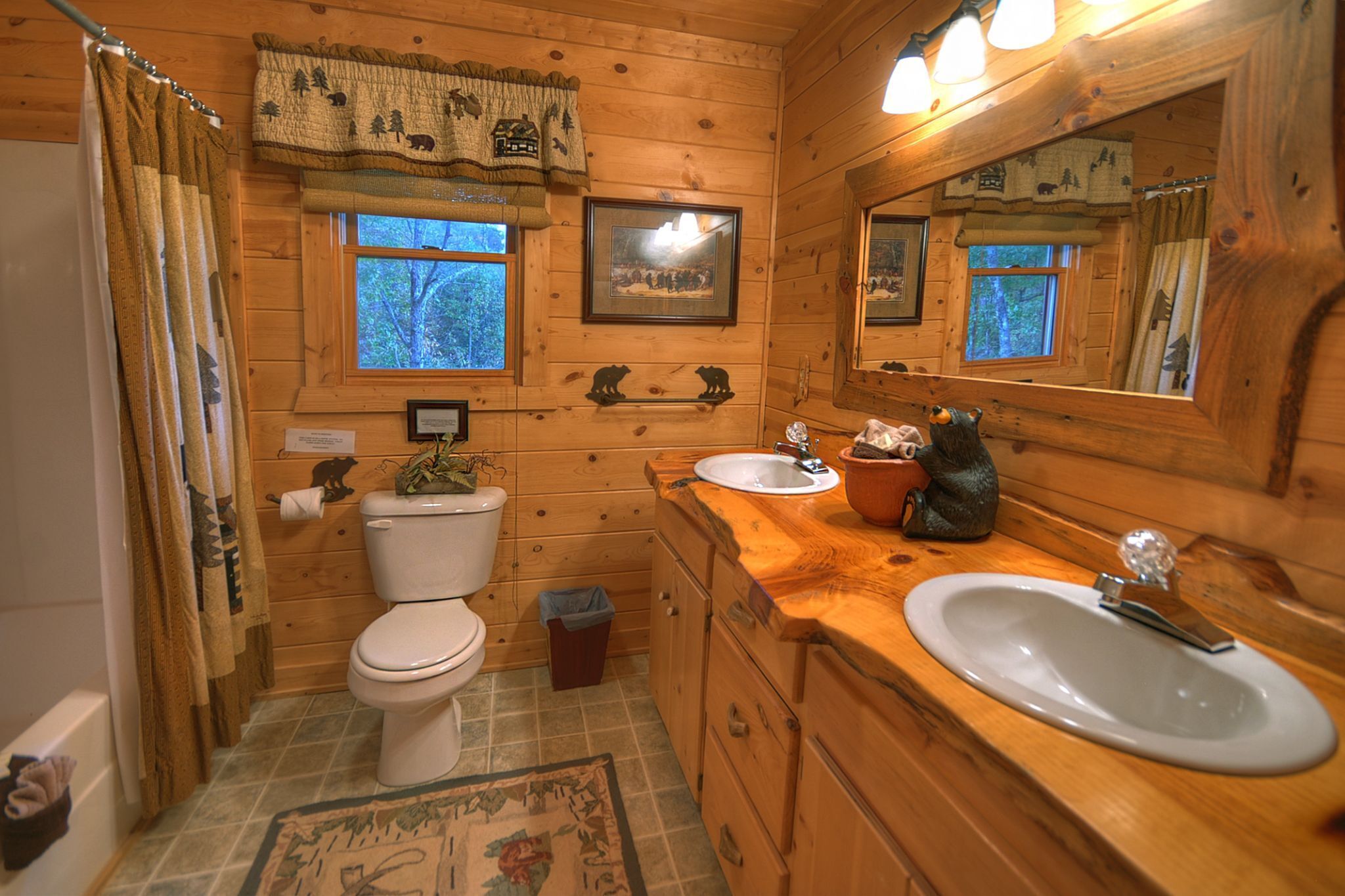 Een houten badkamer in een vakantiehuisje, met toilet, wastafel en spiegel.