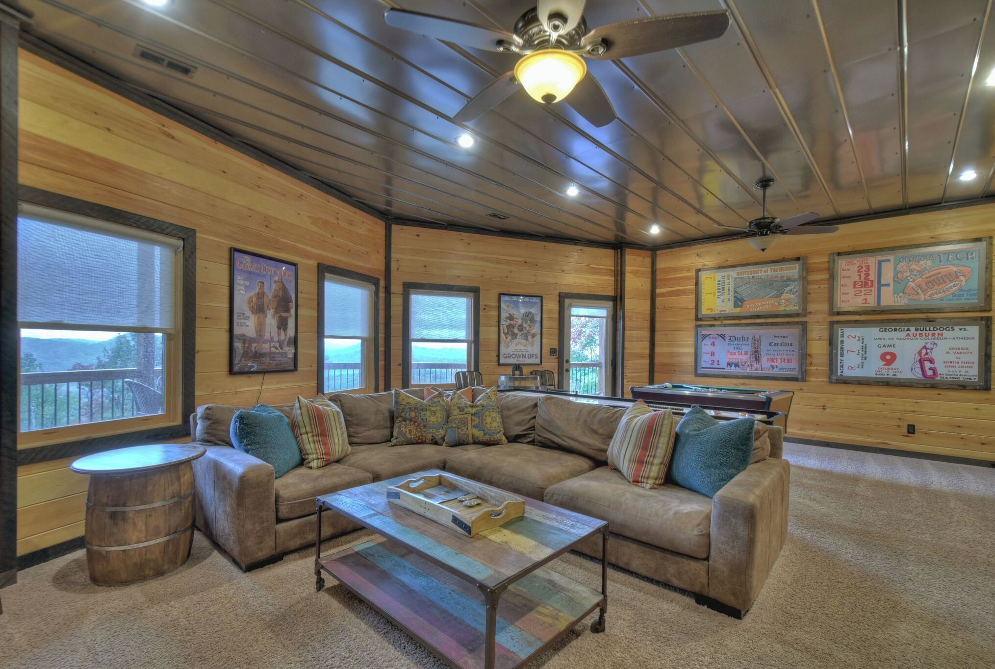 A spacious living room with a large sectional sofa, a coffee table, and a ceiling fan.