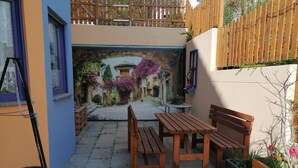 A courtyard with a wooden bench, a table, and a grill. - Beautiful 2-room granny apartment with terrace for 4 people (Burladingen)