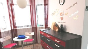 A cafe with a modern interior, featuring a bar area with a coffee machine, a clock, and a menu board displaying coffee options. - Beautiful 2-room granny apartment with terrace for 4 people (Burladingen)