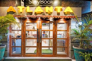 Entrada de un hotel con un letrero que dice "ATLANTA" y un letrero de "StayBook" encima.