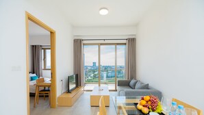 Una sala moderna con sofá, mesa de comedor y vista a la ciudad.