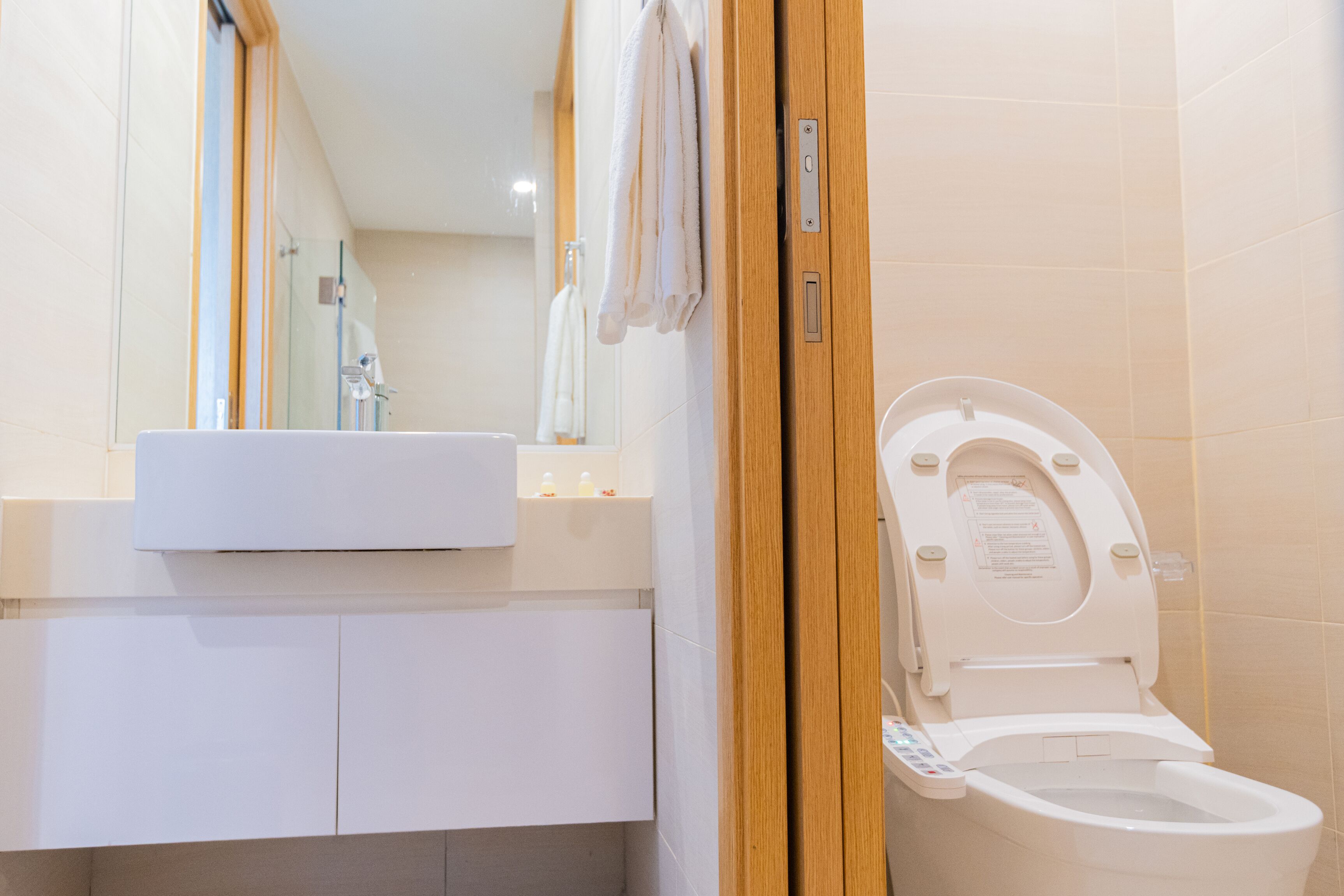 Et moderne badeværelse med toilet, vask og spejl.