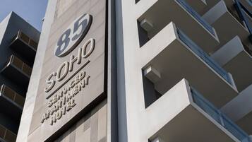 Un edificio moderno con un cartello che riporta la scritta "85 Serviced Apartment Hotel".