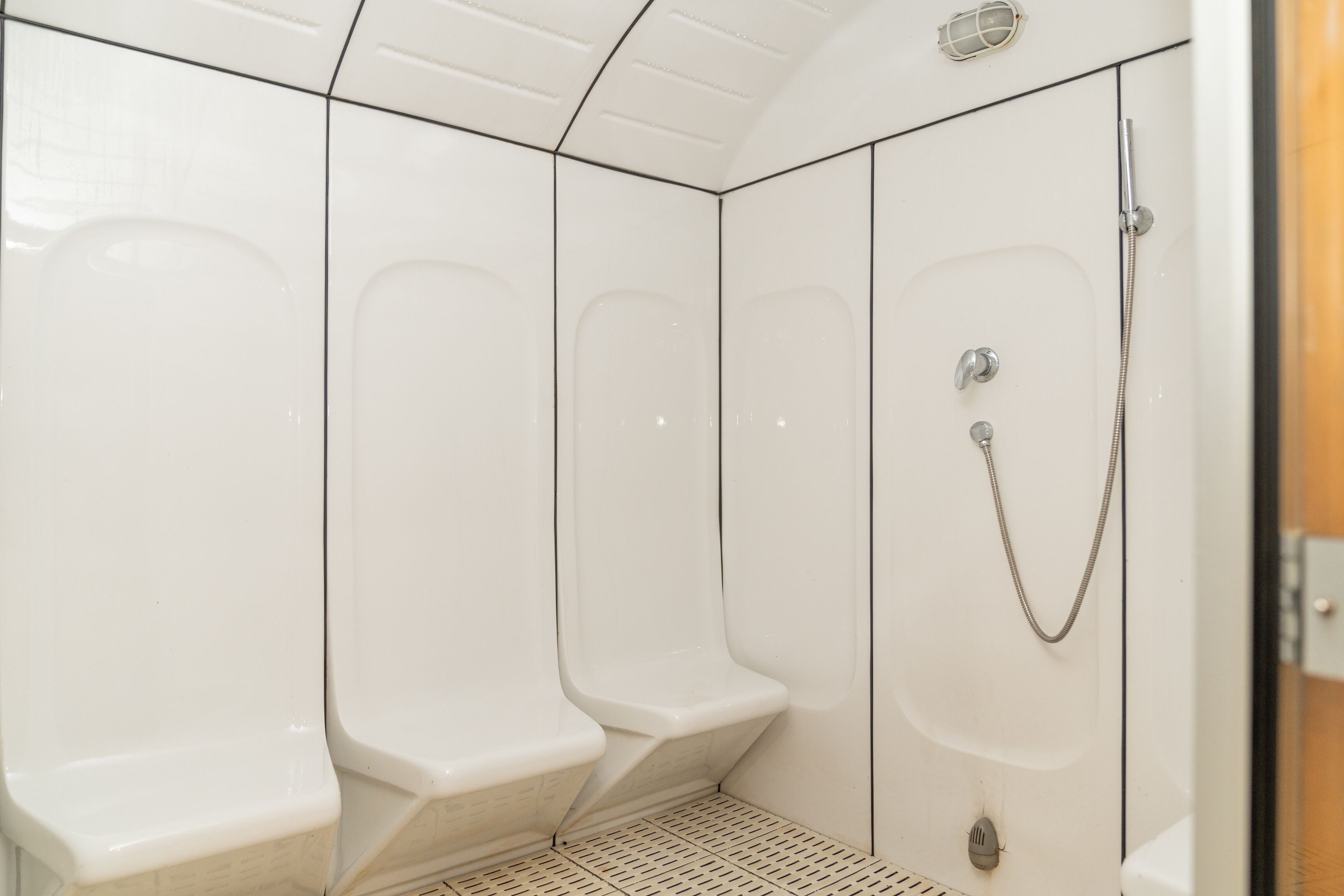 A modern bathroom with white walls and a shower area.