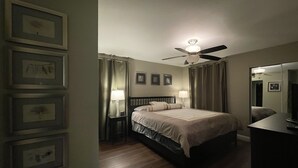 A bedroom with a bed, two bedside tables with lamps, a ceiling fan, and framed pictures on the wall. - Super Clean and Quiet Luxury Condo on the 2nd Floor (Las Vegas)