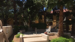 A courtyard with a pool, lounge chairs, and a palm tree. - Super Clean and Quiet Luxury Condo on the 2nd Floor (Las Vegas)