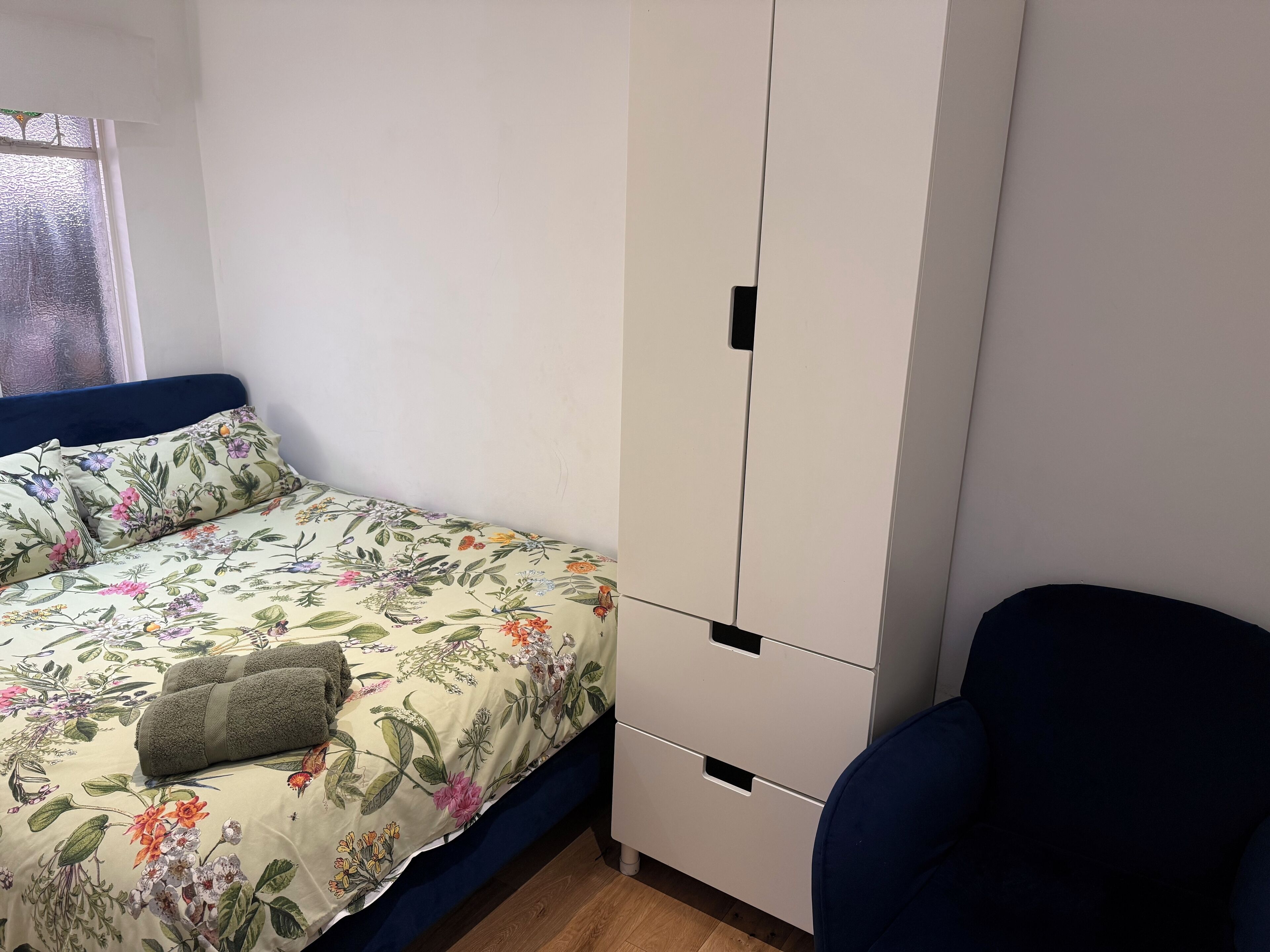 Una camera da letto con un letto, un armadio e una sedia.