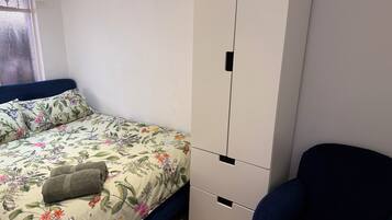 Une chambre à coucher avec un lit, une armoire et une chaise.