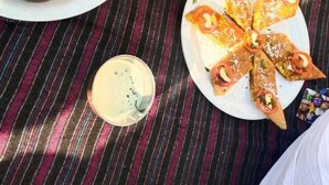 A table with food and drinks, including a bowl of soup, plates of stuffed flatbread, and small bowls of condiments. - Udiksh Hotel and Restaurants (Rohtak)