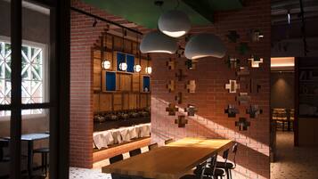 A restaurant with a brick wall, wooden tables, and hanging pendant lights.