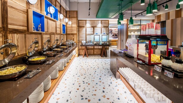 A buffet area with various food stations, including a popcorn machine and a beverage dispenser. - Royal Group Hotel  Xiong Zhong  Branch (Kaohsiung)