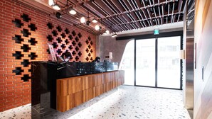 A reception area with a brick wall, a wooden reception desk, and a terrazzo floor. - Royal Group Hotel  Xiong Zhong  Branch (Kaohsiung)
