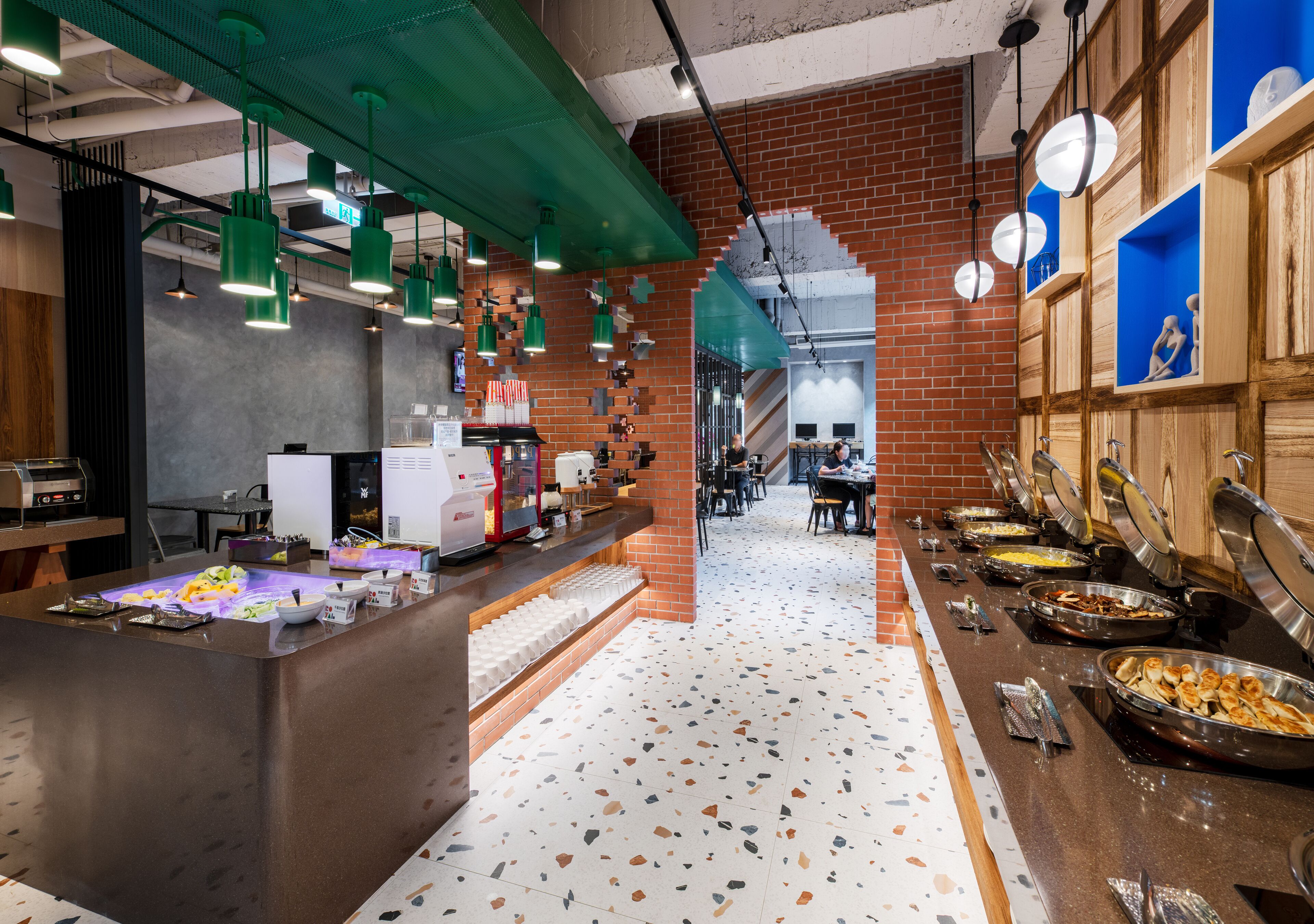 A buffet area with various food stations, a coffee machine, and seating arrangements.