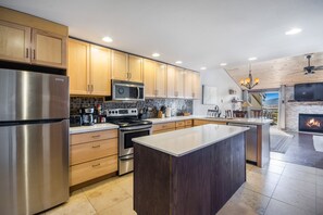 Enjoy cooking in this well-lit kitchen with a central island, stainless steel appliances, and cabinetry.