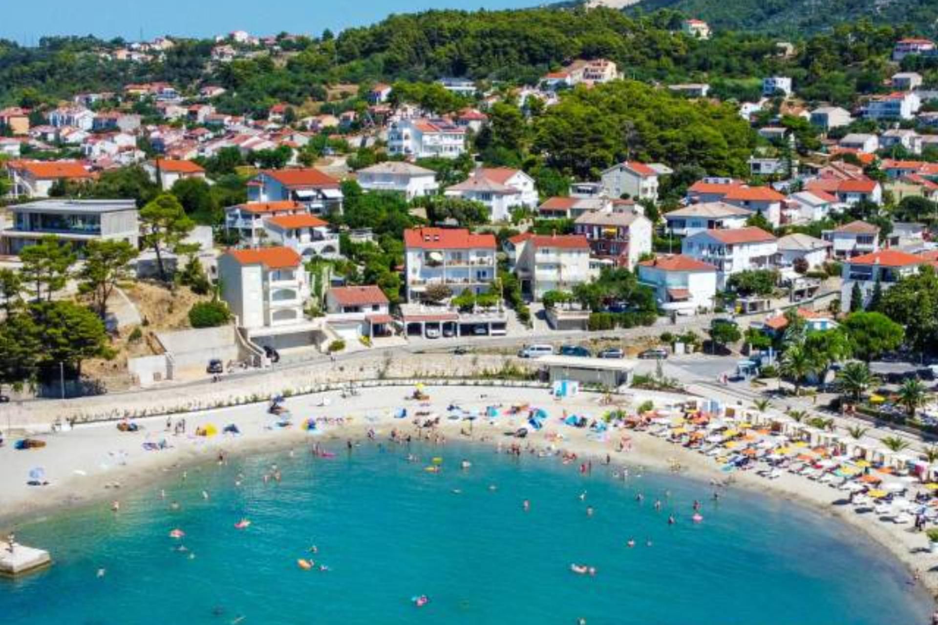 Une ville côtière avec une plage, des maisons et un ciel dégagé.