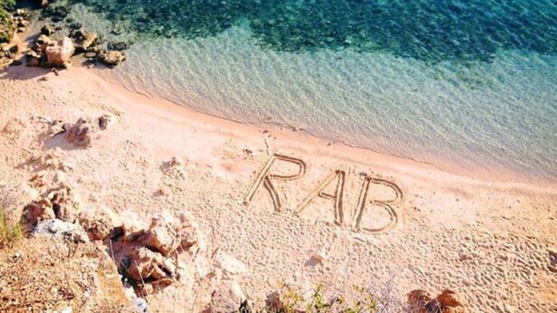 Una playa con la palabra "RAB" escrita en la arena.