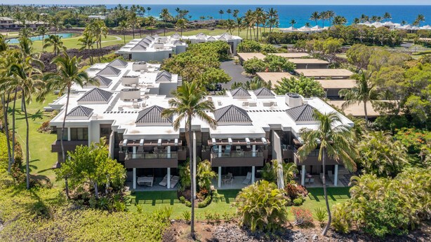 Ein Resort mit mehreren Gebäuden, einem Pool und Palmen.