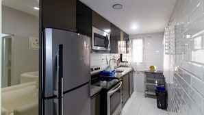 Een moderne keuken met roestvrijstalen apparatuur, een magnetron en een spoelbak.