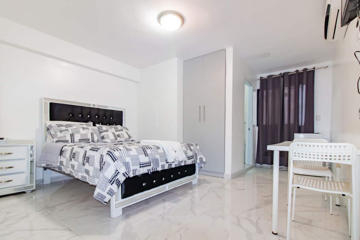 A modern bedroom with a bed, a desk, and a chair.