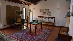Ein gemütliches Wohnzimmer mit Billardtisch, einer Couch und einem Essbereich mit Stühlen.