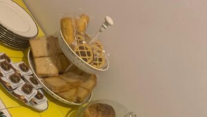 A kitchen counter with various baked goods displayed on clear glass plates and a stand. - Hotel Oceania (Naples)