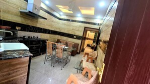 A kitchen with a dining area, a microwave, a stove, and a sink. - Smart Apartments & Hotel (Lahore)