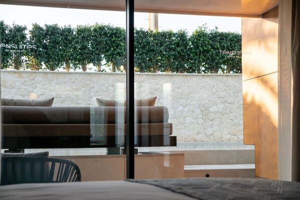 Una habitación moderna con pared de piedra, un sofá y una partición de vidrio.