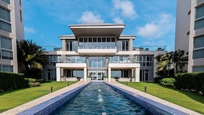 A modern hotel with a central pool, two-story structure, and balconies. - 3 bdrm/2 bath Villa w/pool, Azure Beach Residences (Oranjestad-West)