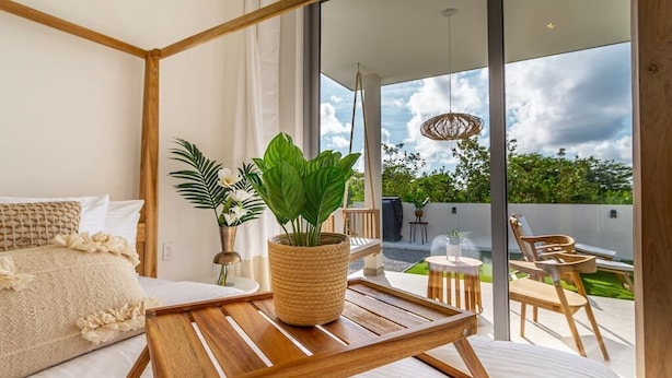 A modern bedroom with a large bed, a wooden side table, and a potted plant. - 3 bdrm/2 bath Villa w/pool, Azure Beach Residences (Oranjestad-West)
